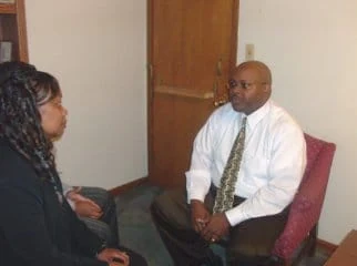 A man and woman seated across from one another in an office.