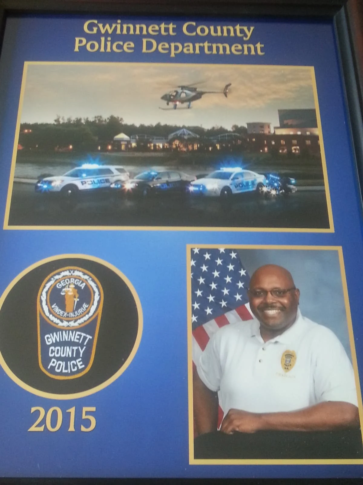 A framed 2015 Gwinnett County Police Department display with a chaplain portrait.