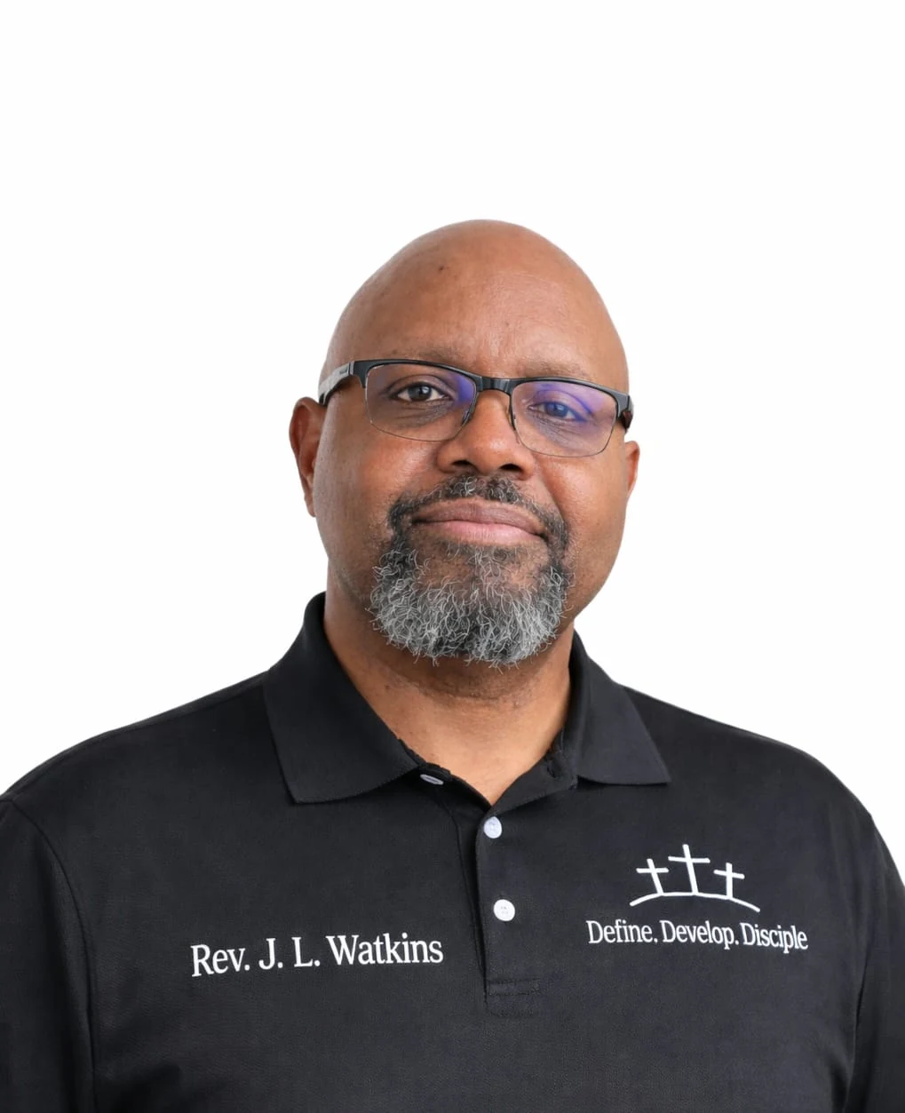 Professional portrait of a man wearing a black polo embroidered with Rev. J. L. Watkins and Define. Develop. Disciple.